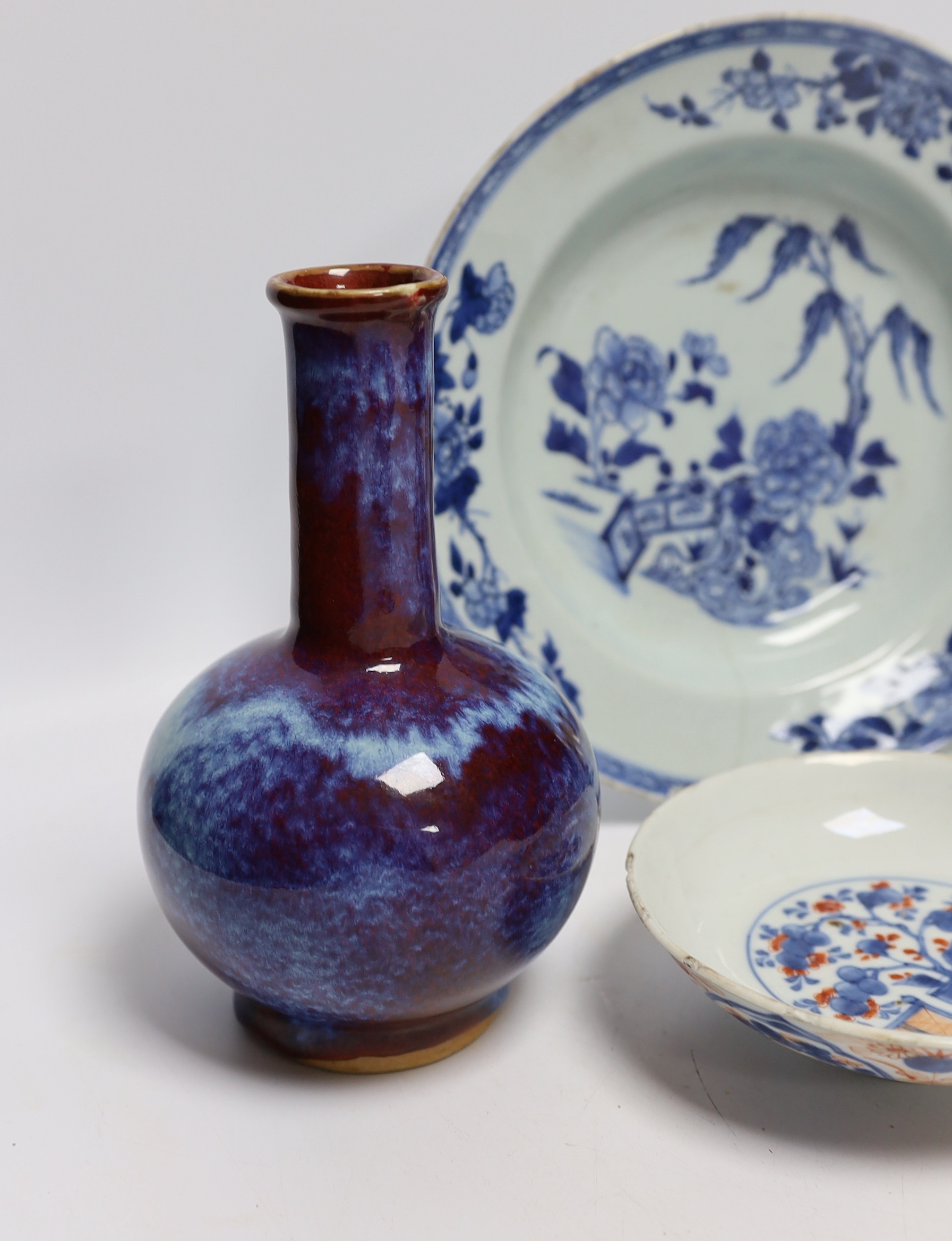 A group of Chinese ceramics including a flambé vase, an 18th century blue and white floral plate and a similar lid, 25cm diameter